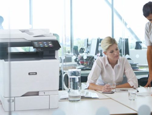 Zwei Frauen arbeiten in einem Büro neben einem Xerox® VersaLink® C625 Farb-Multifunktionsdrucker